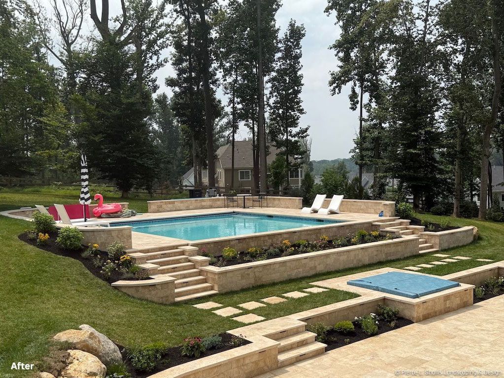 Backyard with a raised swimming pool, hot tub, lounge chairs, and stone steps surrounded by trees