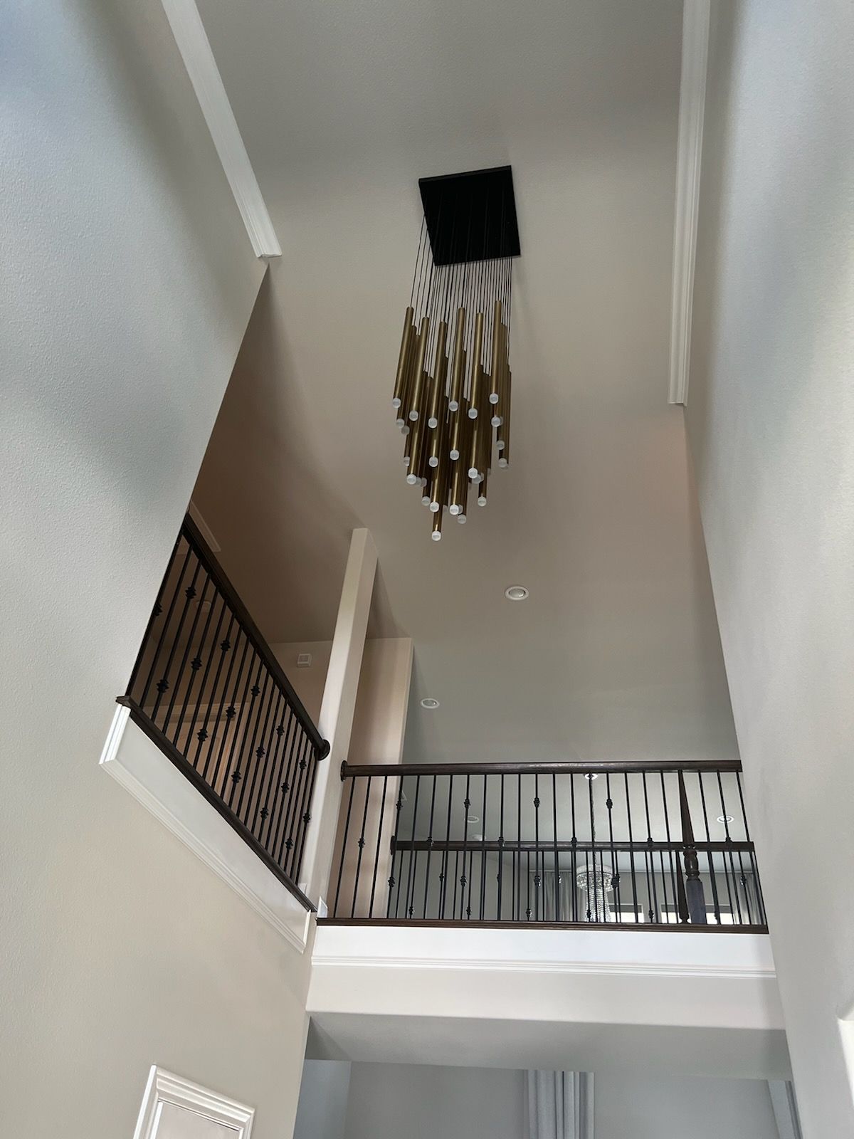 A staircase with a chandelier hanging from the ceiling