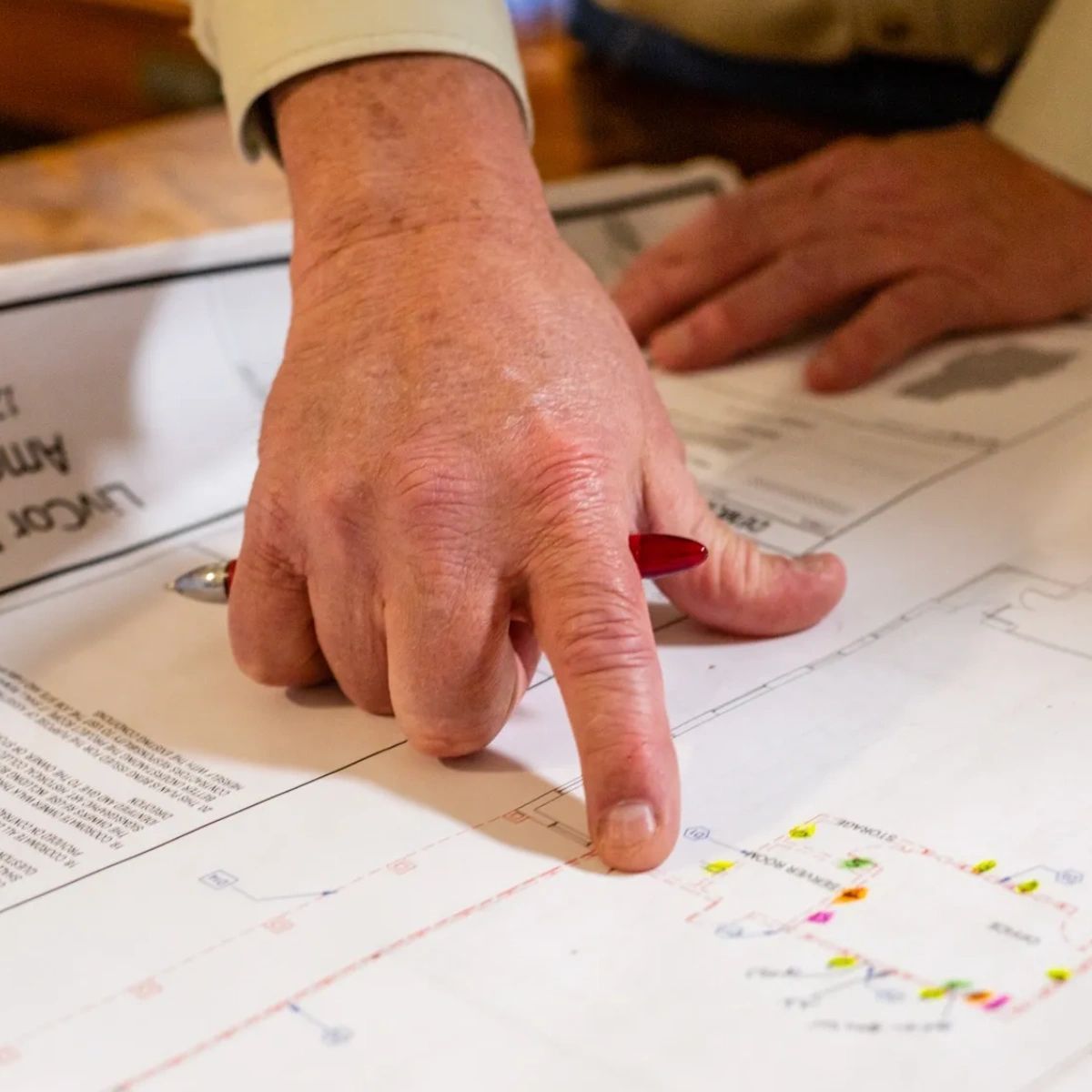 A person 's hand is pointing at a piece of paper that says lucas on it