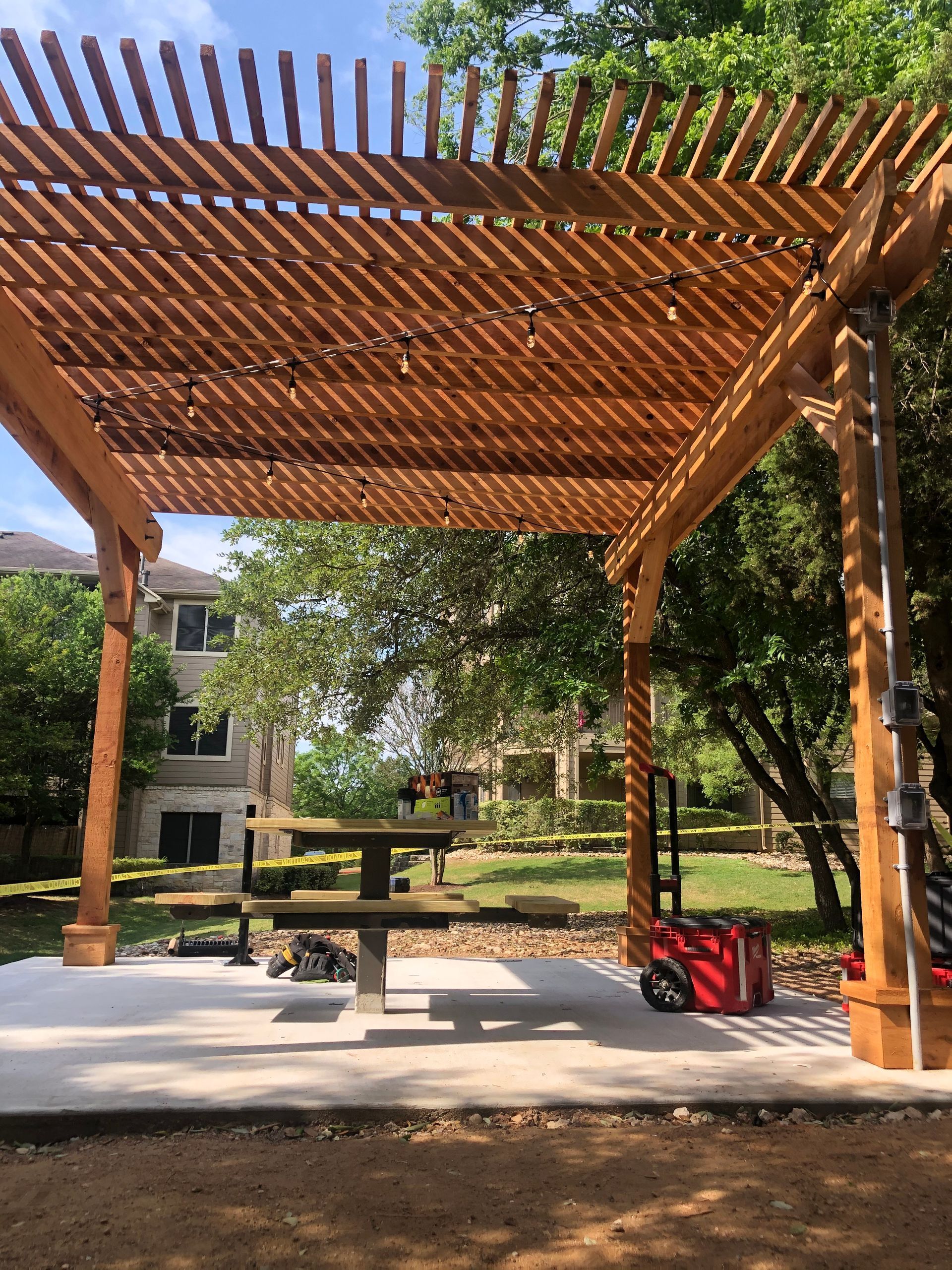 A wooden pergola with a picnic table underneath it.