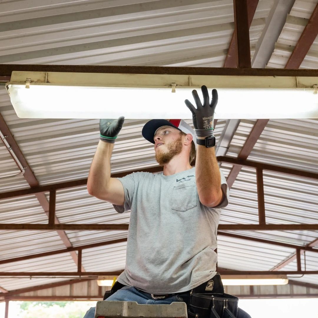 A man is working on a light fixture in a building