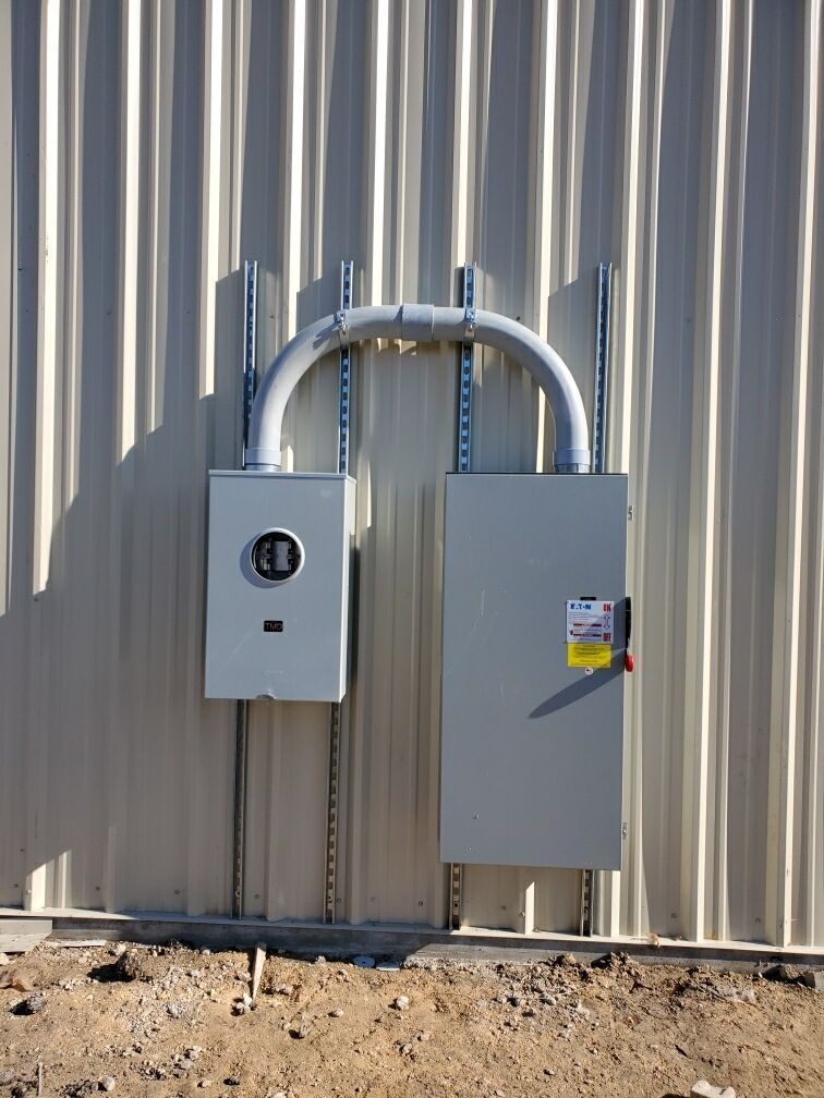 An electrical box is attached to the side of a building