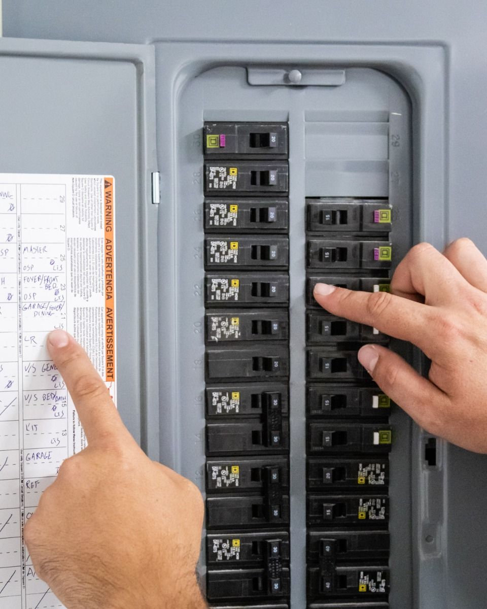 A person is pressing a button on an electrical panel