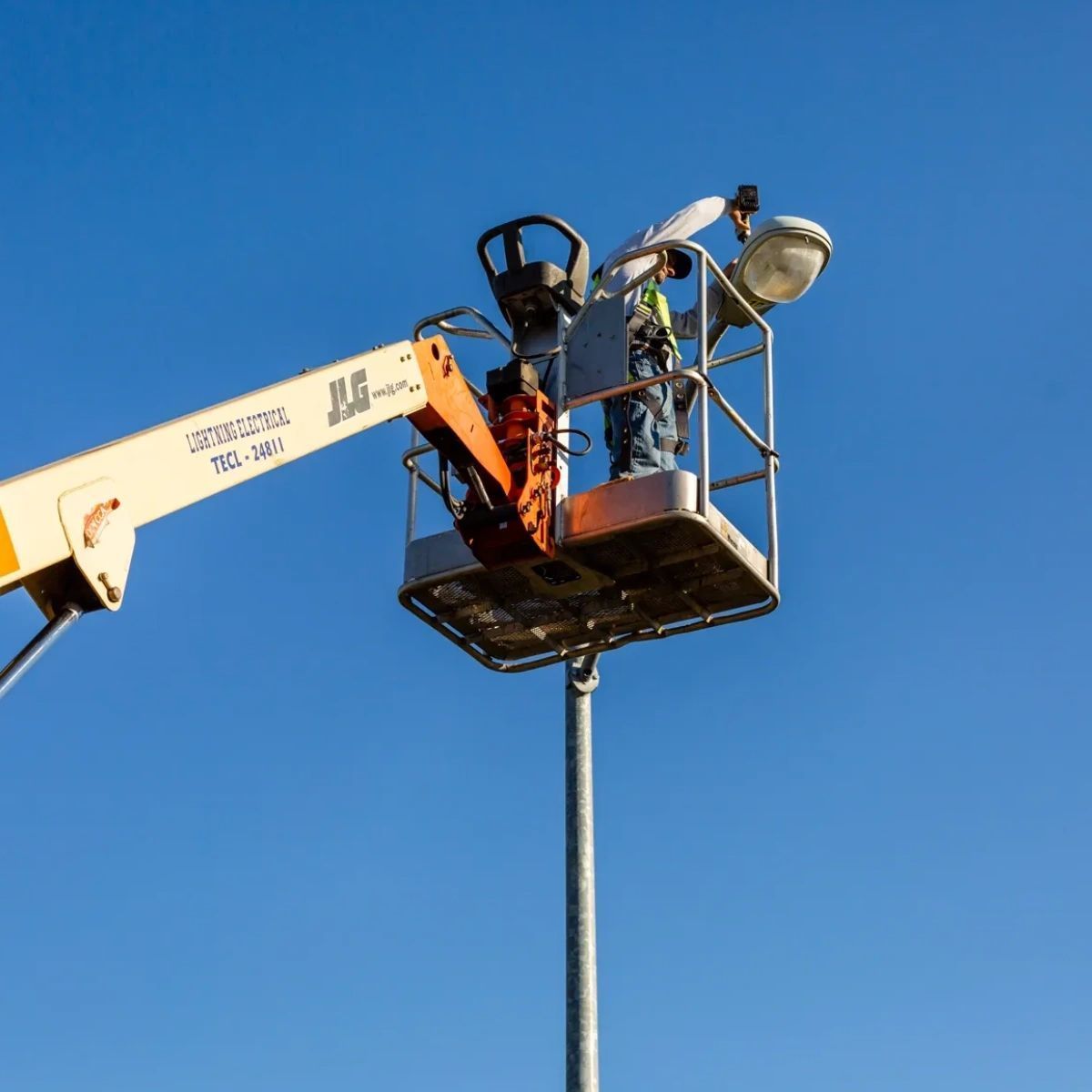 A man is working on a street light in a jlg lift