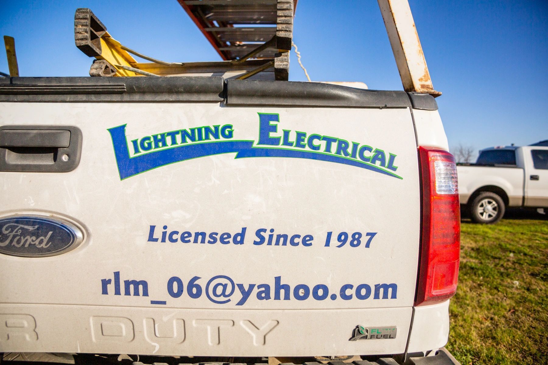 The back of a white ford truck says lightning electrical