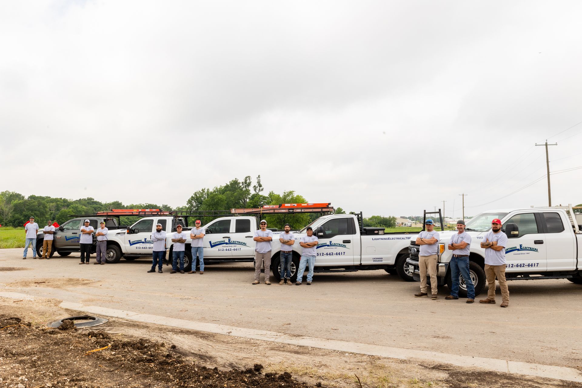 A group of people standing in front of a row of trucks.