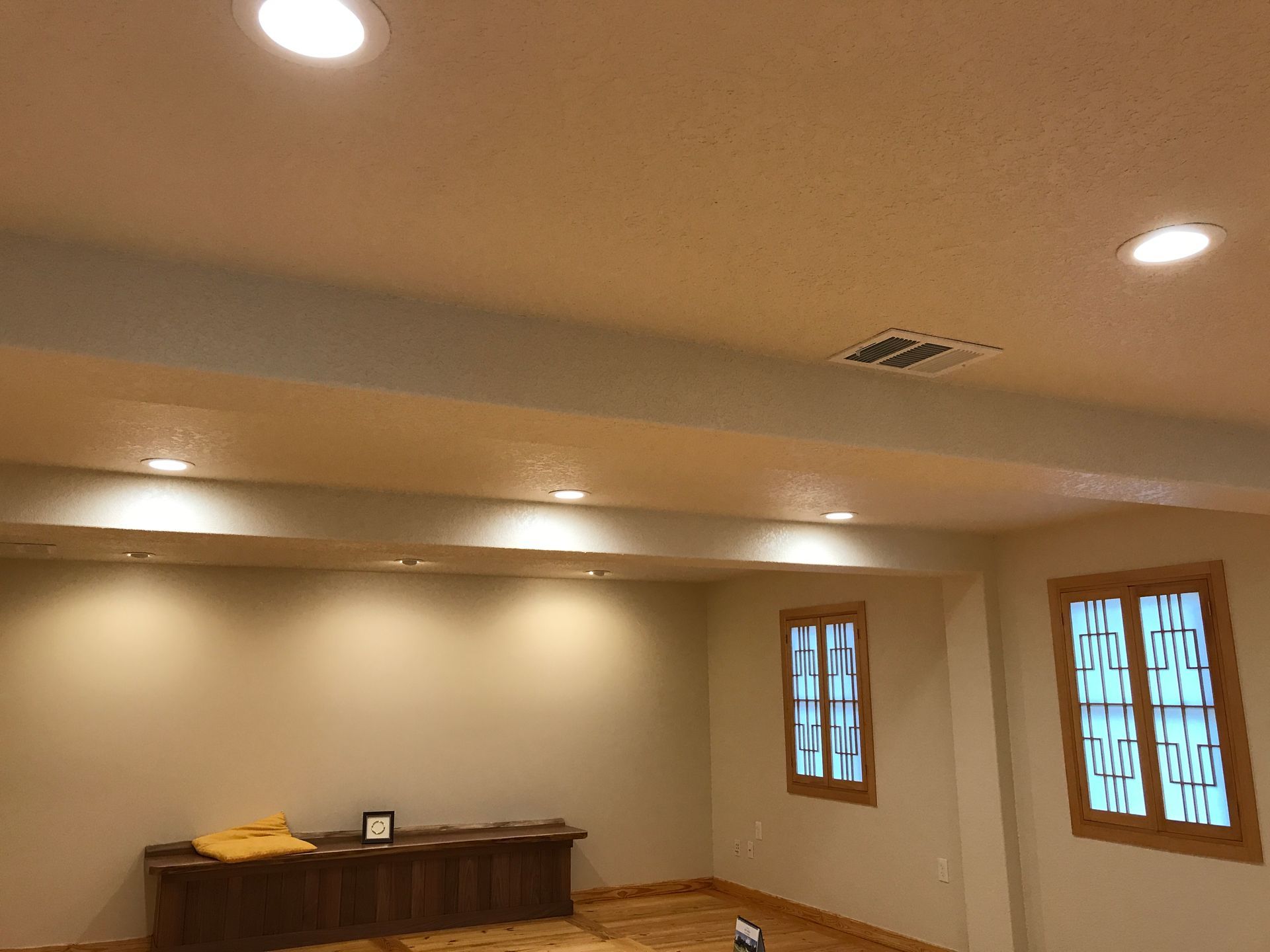 A living room with a ceiling fan and two windows.