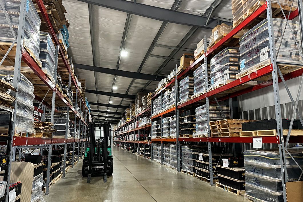 A forklift in a large warehouse filled with shelves