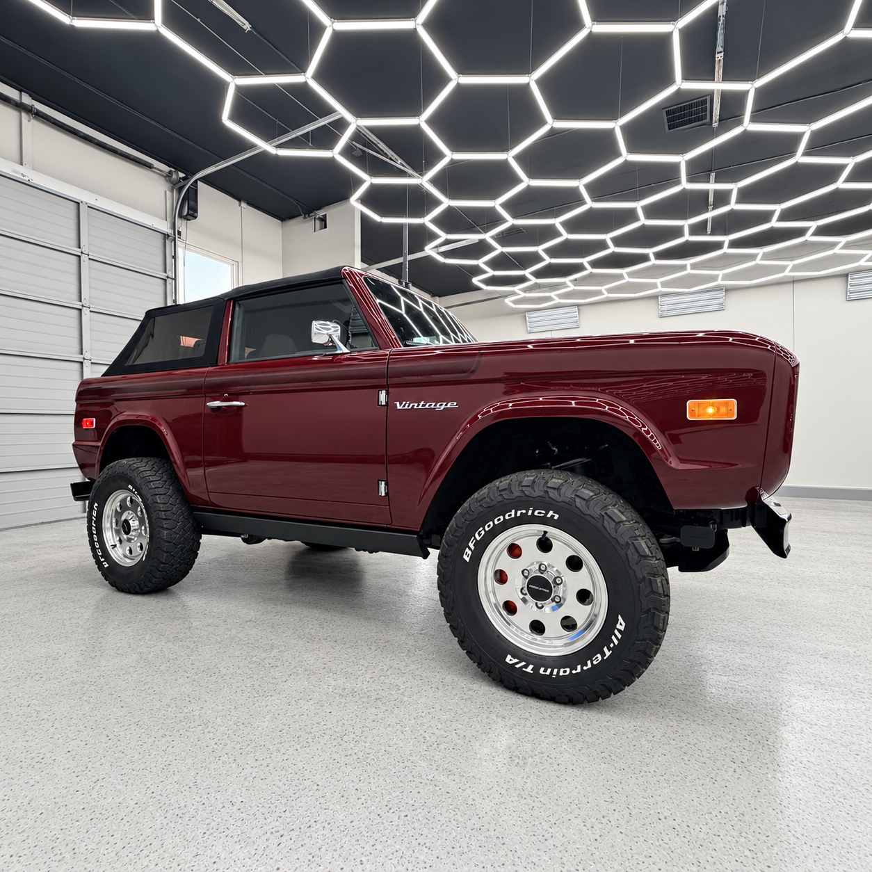 Maroon classic off-road SUV in a bright showroom with geometric ceiling lights