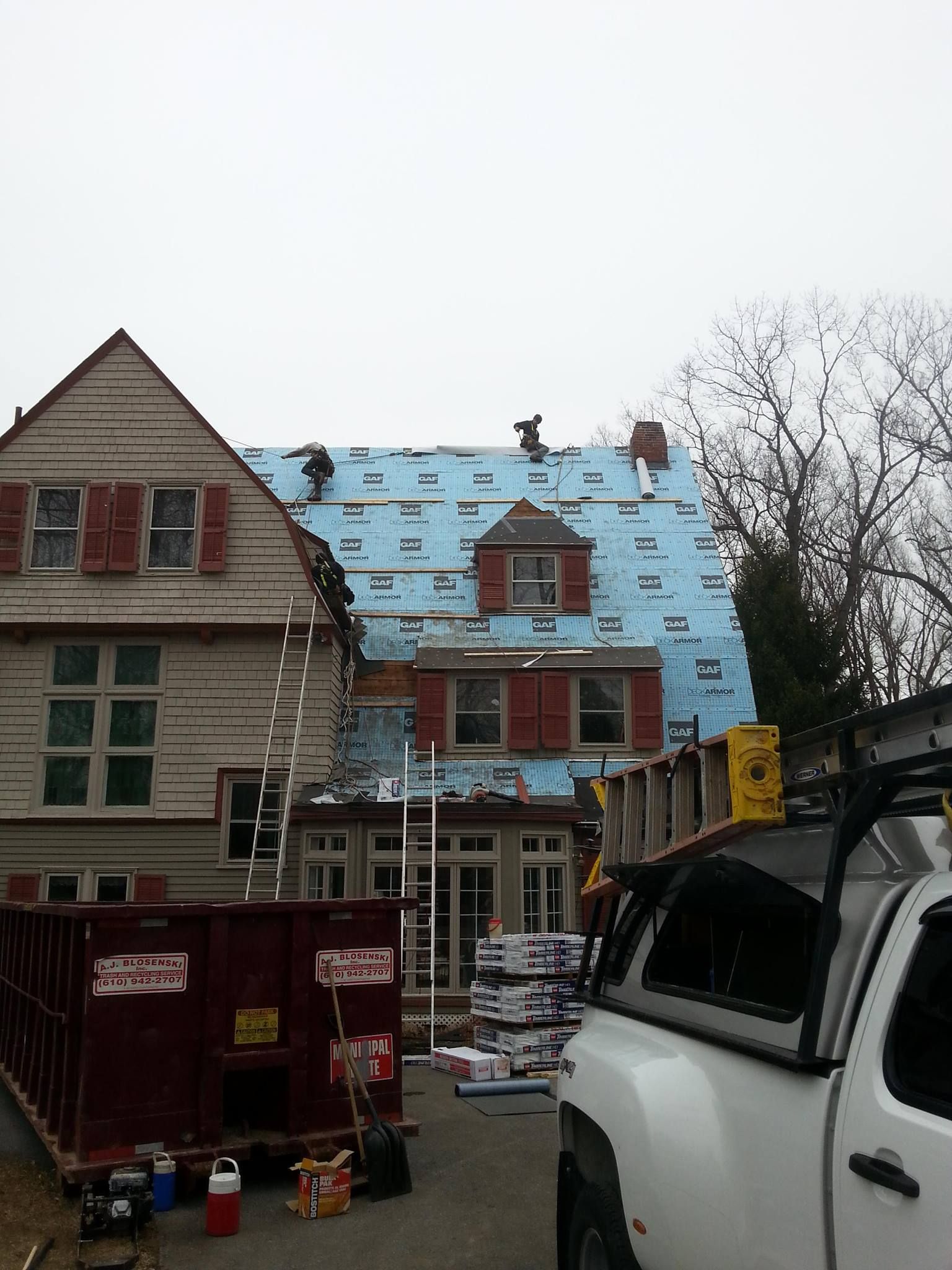 A white truck is parked in front of a house under construction