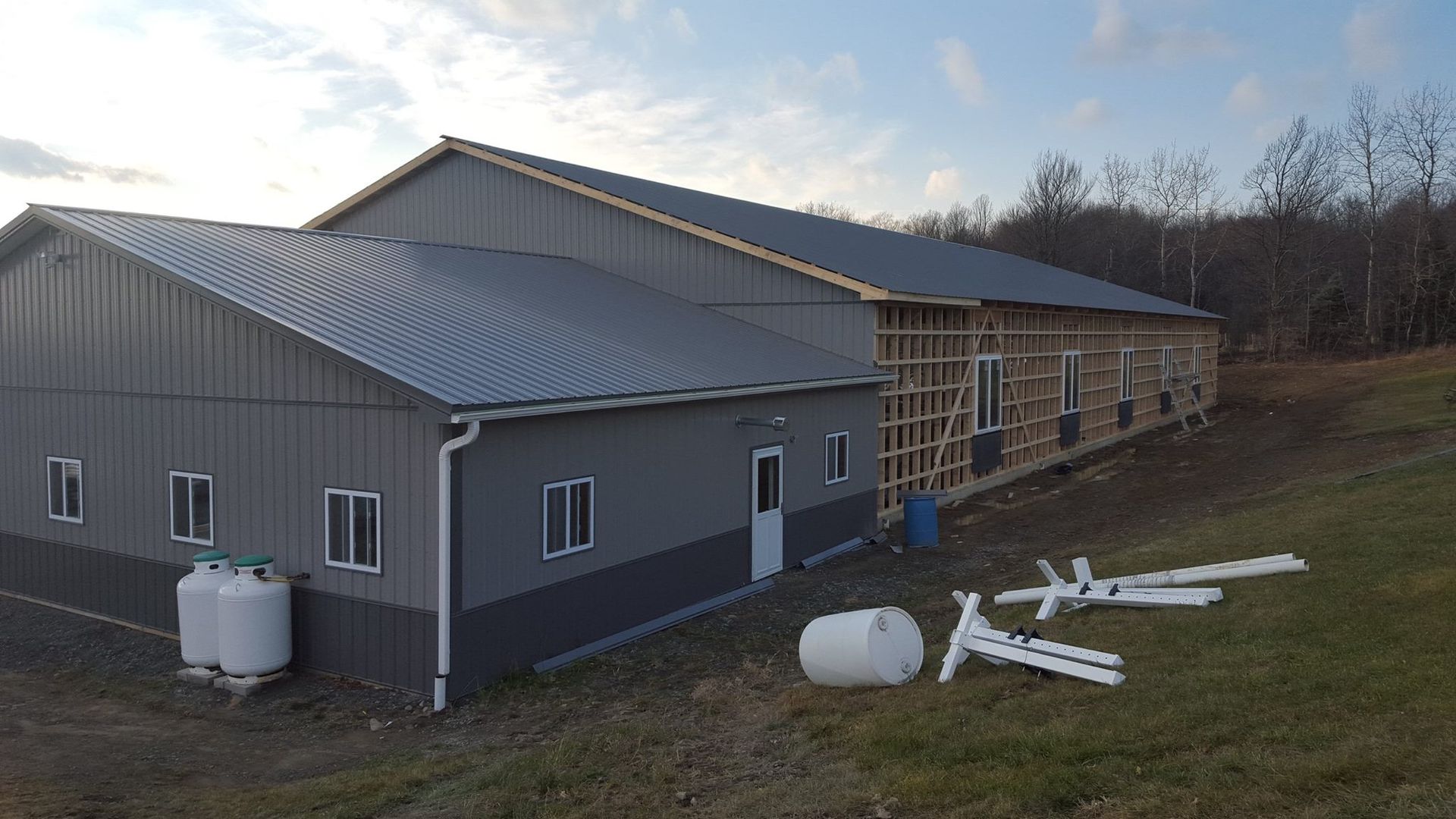 A large building is being built in the middle of a field.