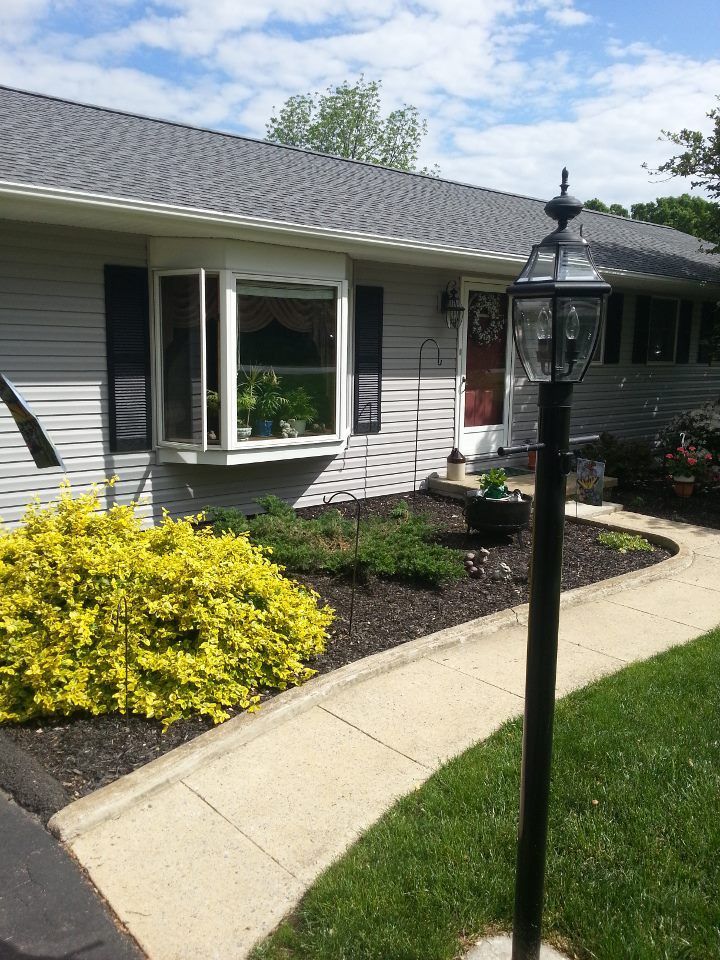 A house with a walkway and a lamp post in front of it