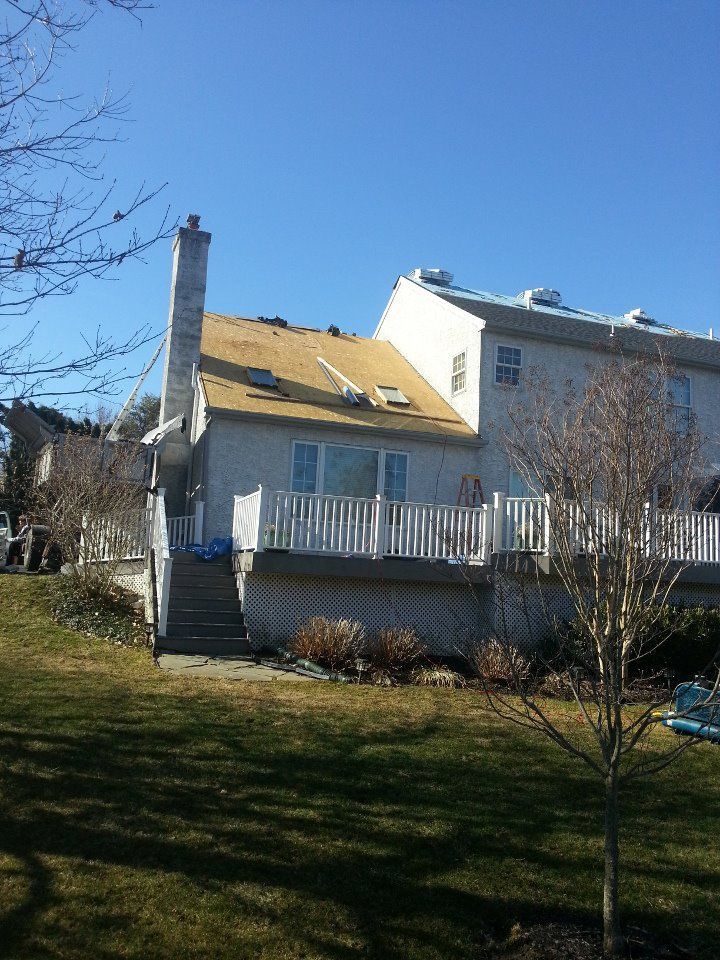 The back of a house with a deck and stairs leading up to it.