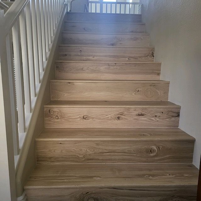Wooden stairs with a white railing leading upwards in a home.