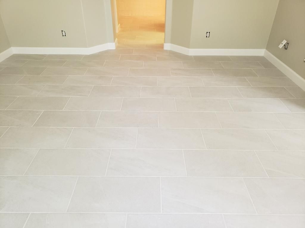 Light gray tiled floor in a room with beige walls and white trim.