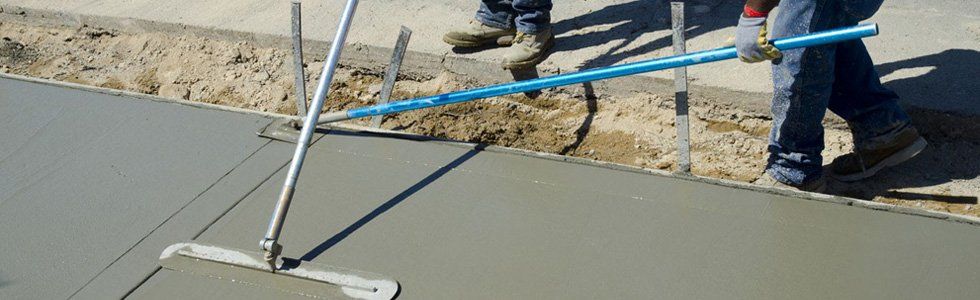 Workmen finish and smooth concrete surface