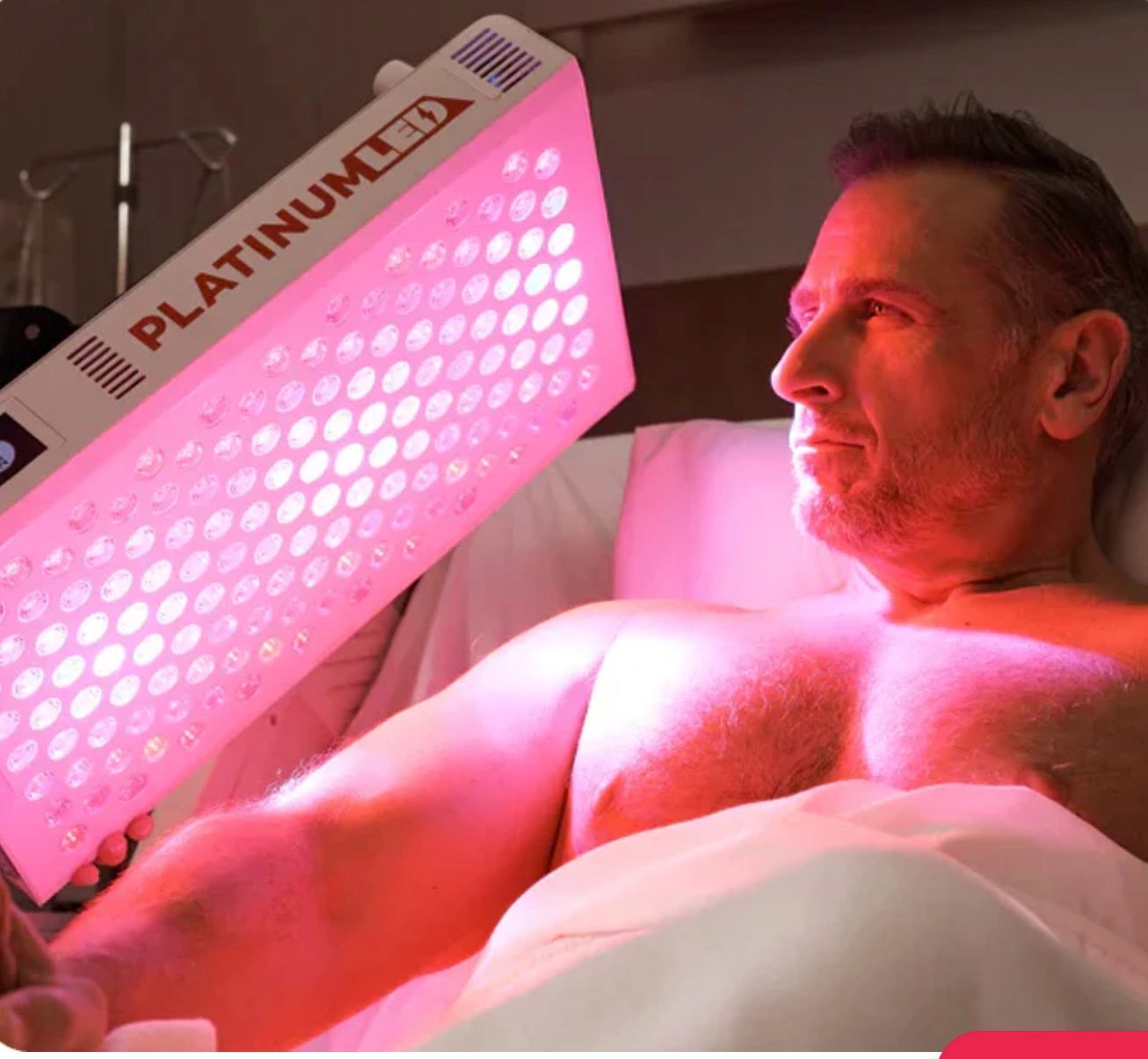 Man receiving red light therapy treatment on his arm.