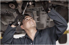 Auto repairman fixing the bottom part of the car