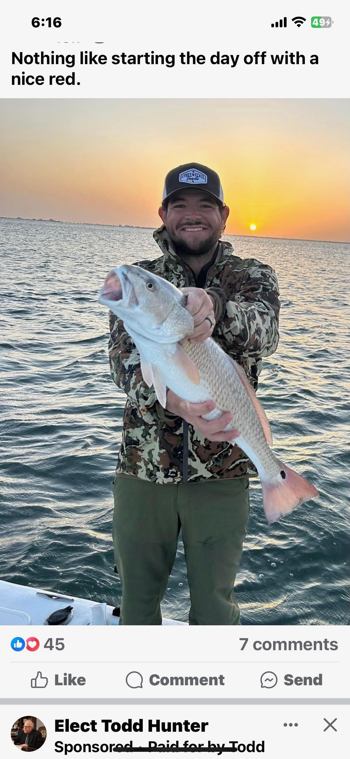 A man is holding a large fish in his hands on a boat.
