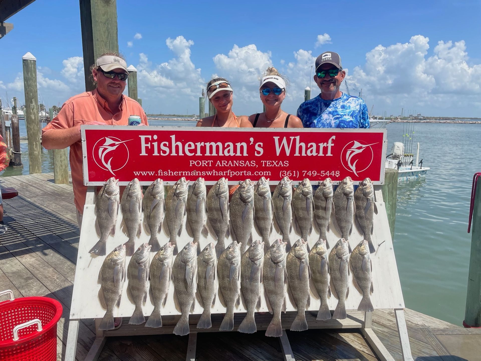 A group of people are standing next to a sign that says fisherman 's wharf.