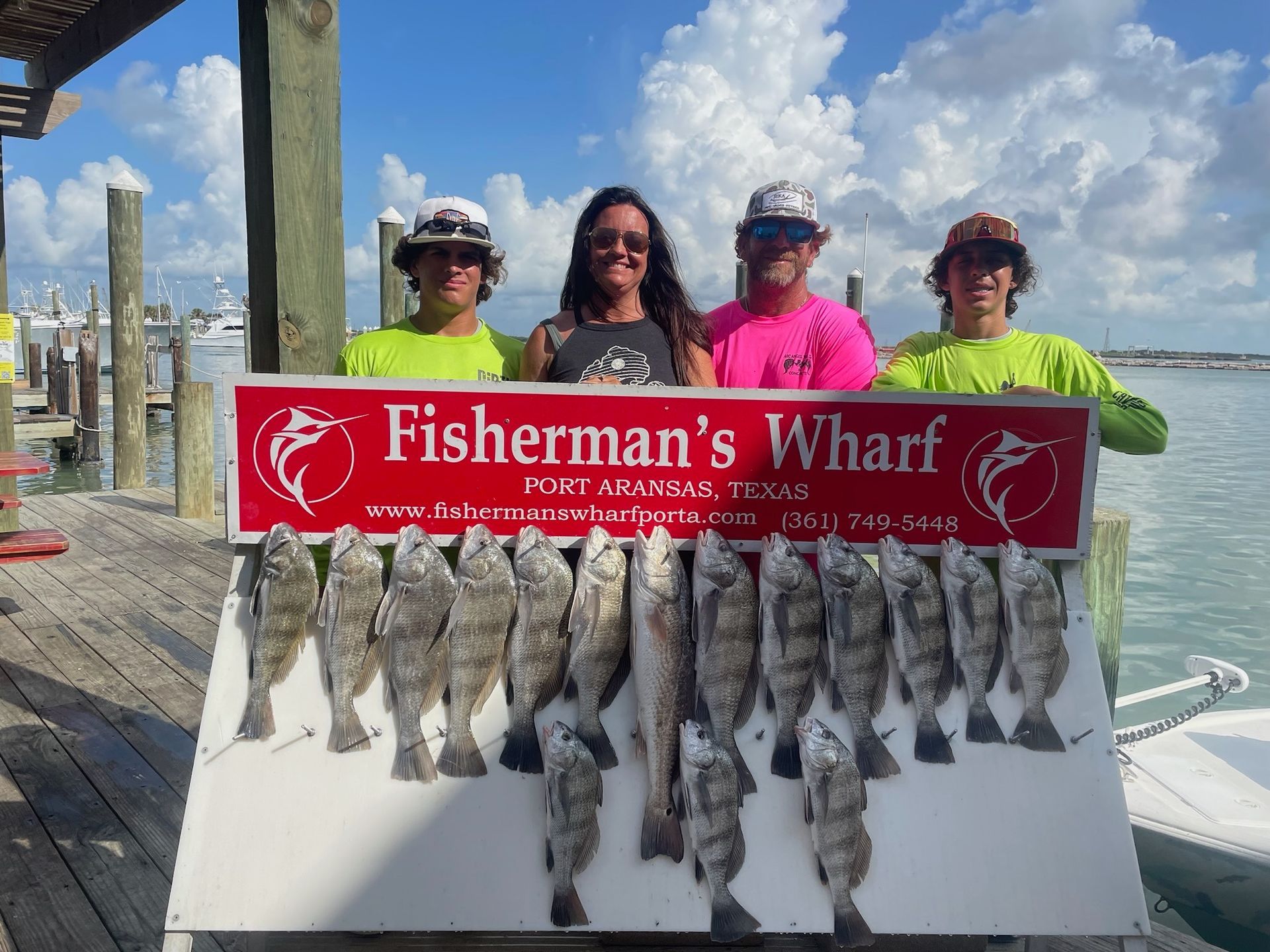 A group of people holding a sign that says fisherman 's wharf