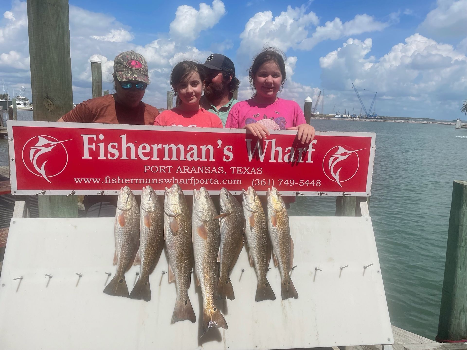 A group of people holding a sign that says fisherman 's wharf