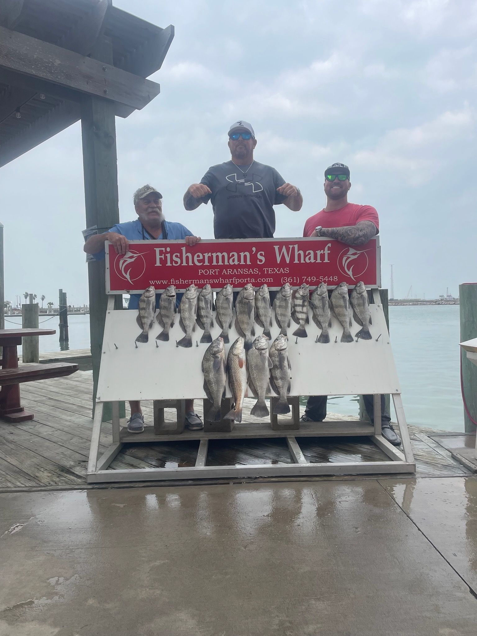 Three men standing in front of a sign that says fisherman 's hunt