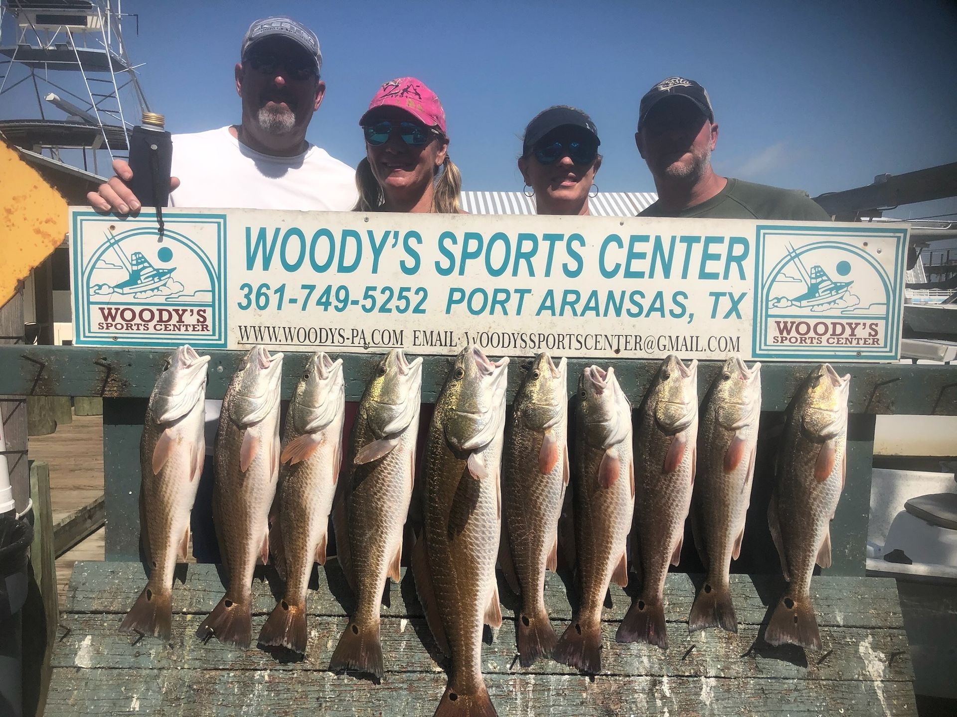 A group of people holding a sign that says woody 's sports center