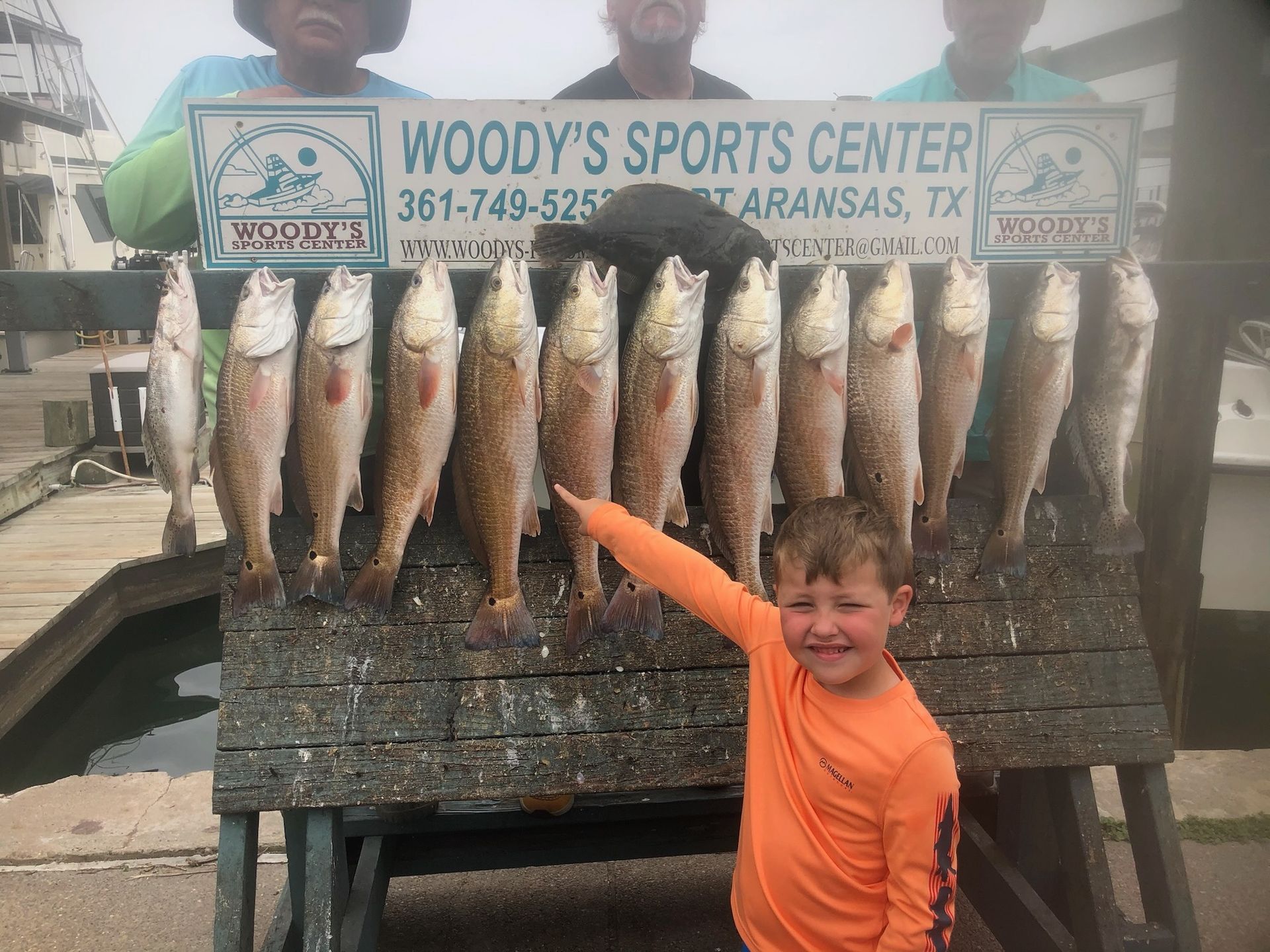 A young boy is standing in front of a display of fish.