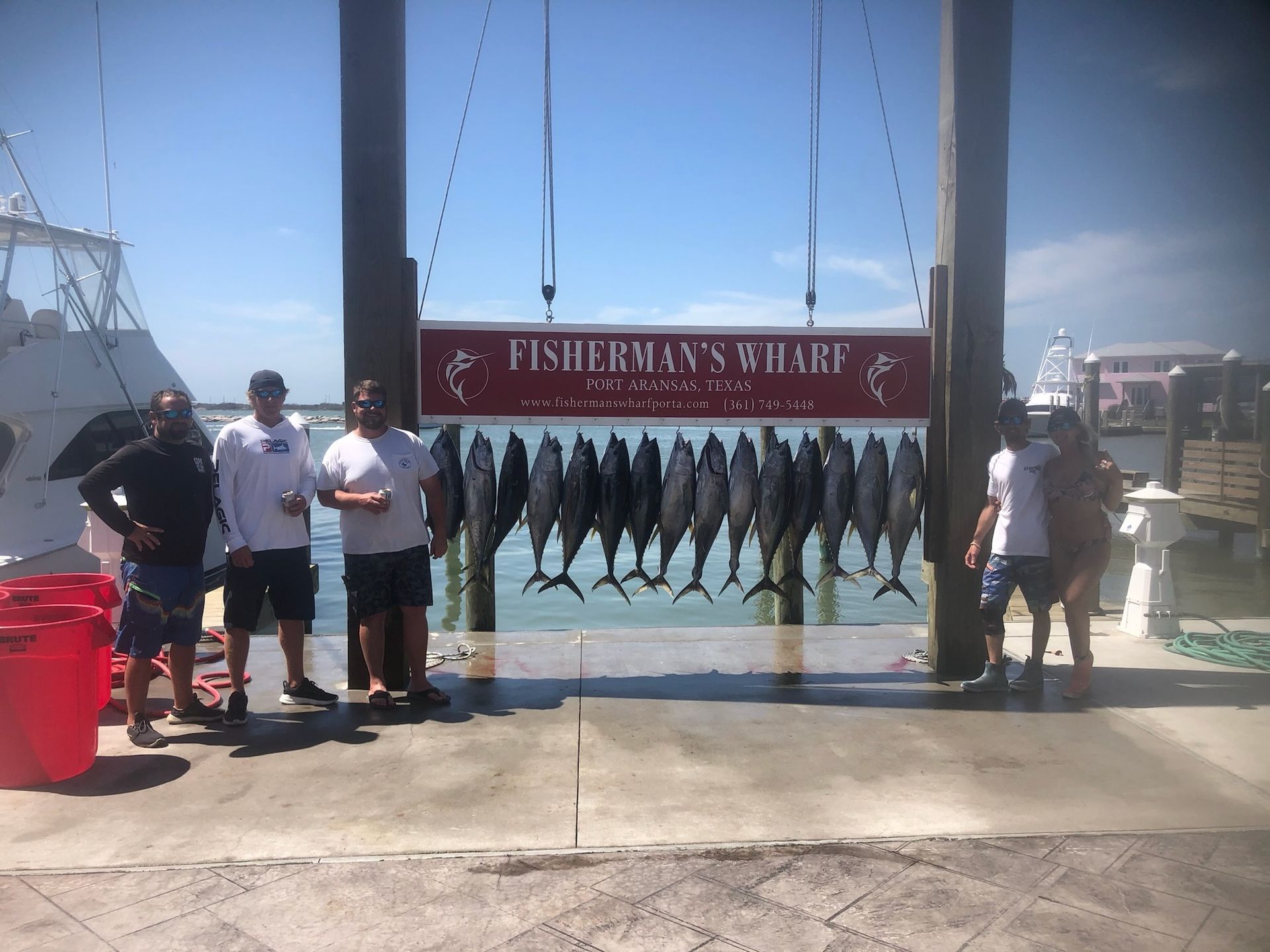 A group of men are standing in front of a sign that says fisherman 's chart.