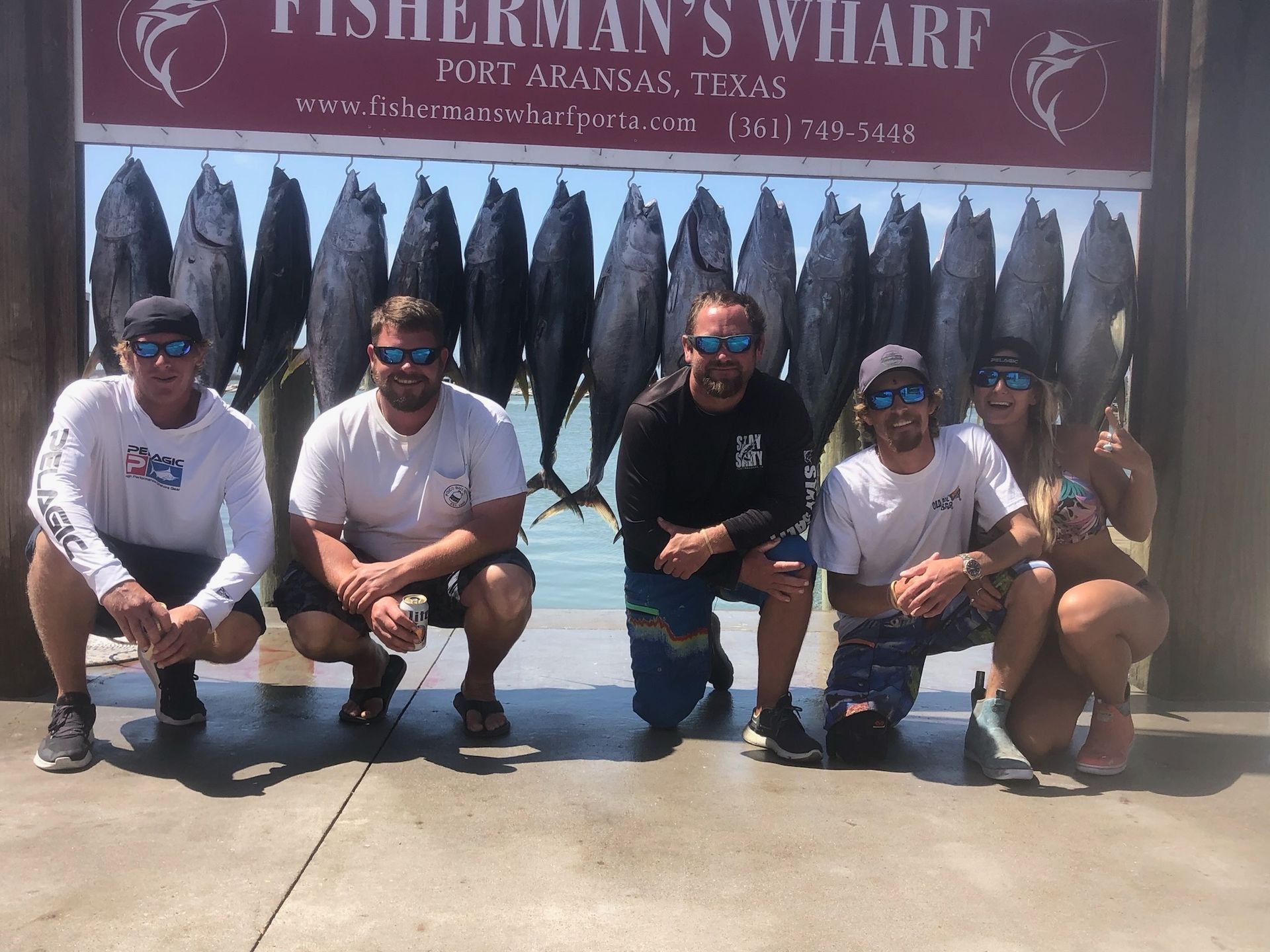 A group of people posing for a picture in front of a sign that says fisherman 's wharf
