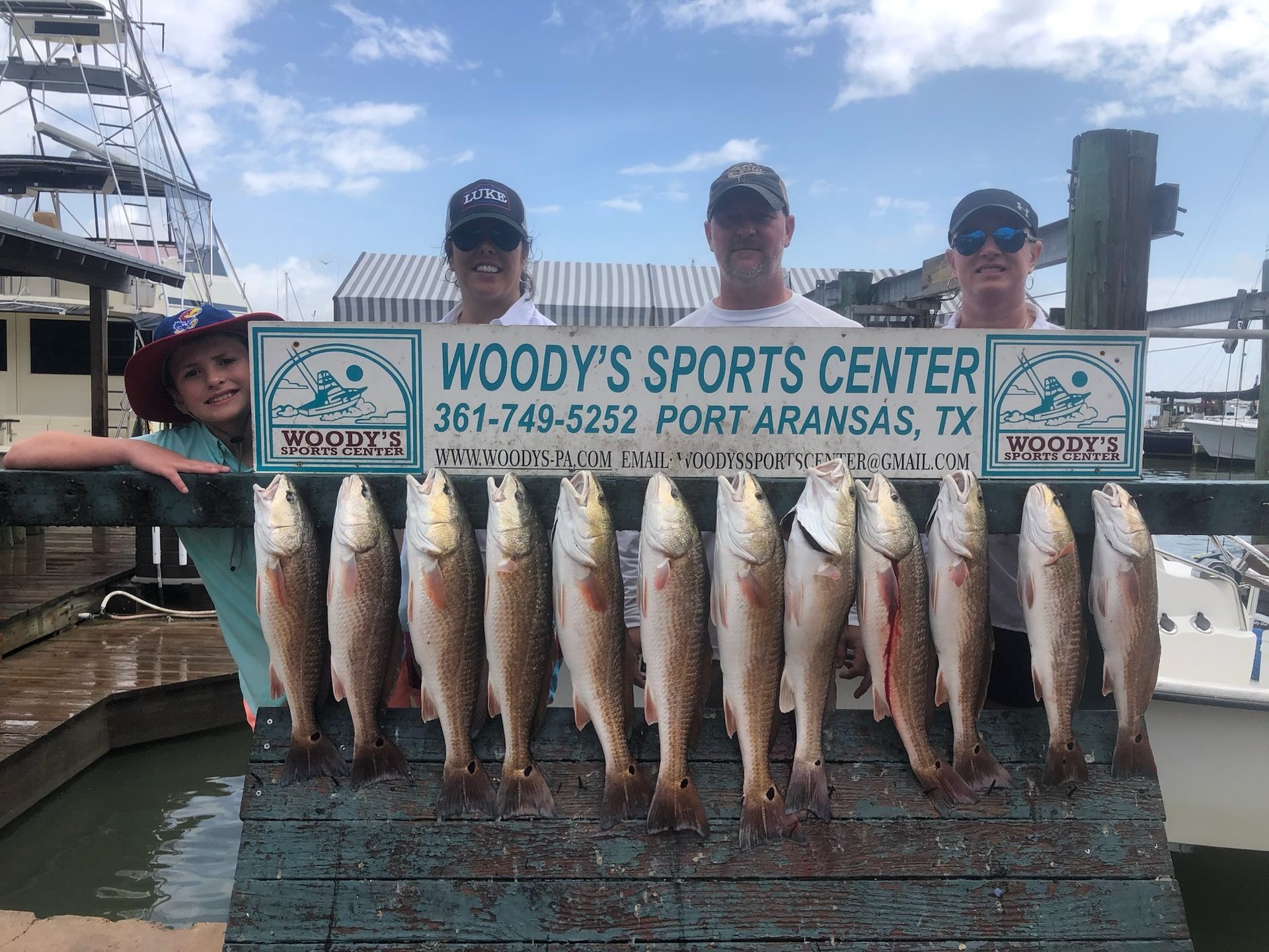 A group of people are holding a sign that says woody 's sports center.