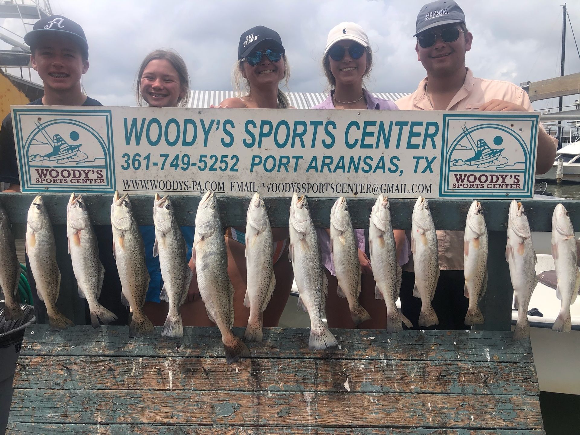 A group of people holding a sign that says woody 's sports center