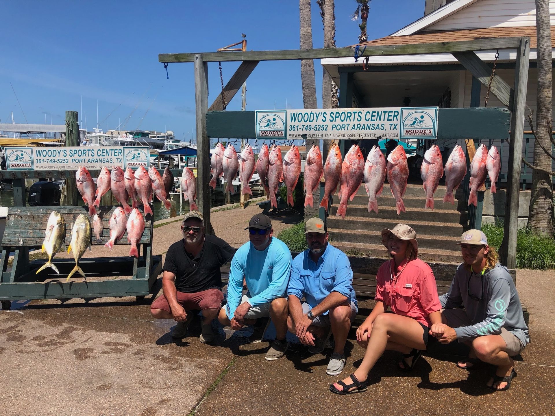 A group of people are posing for a picture in front of a display of fish.