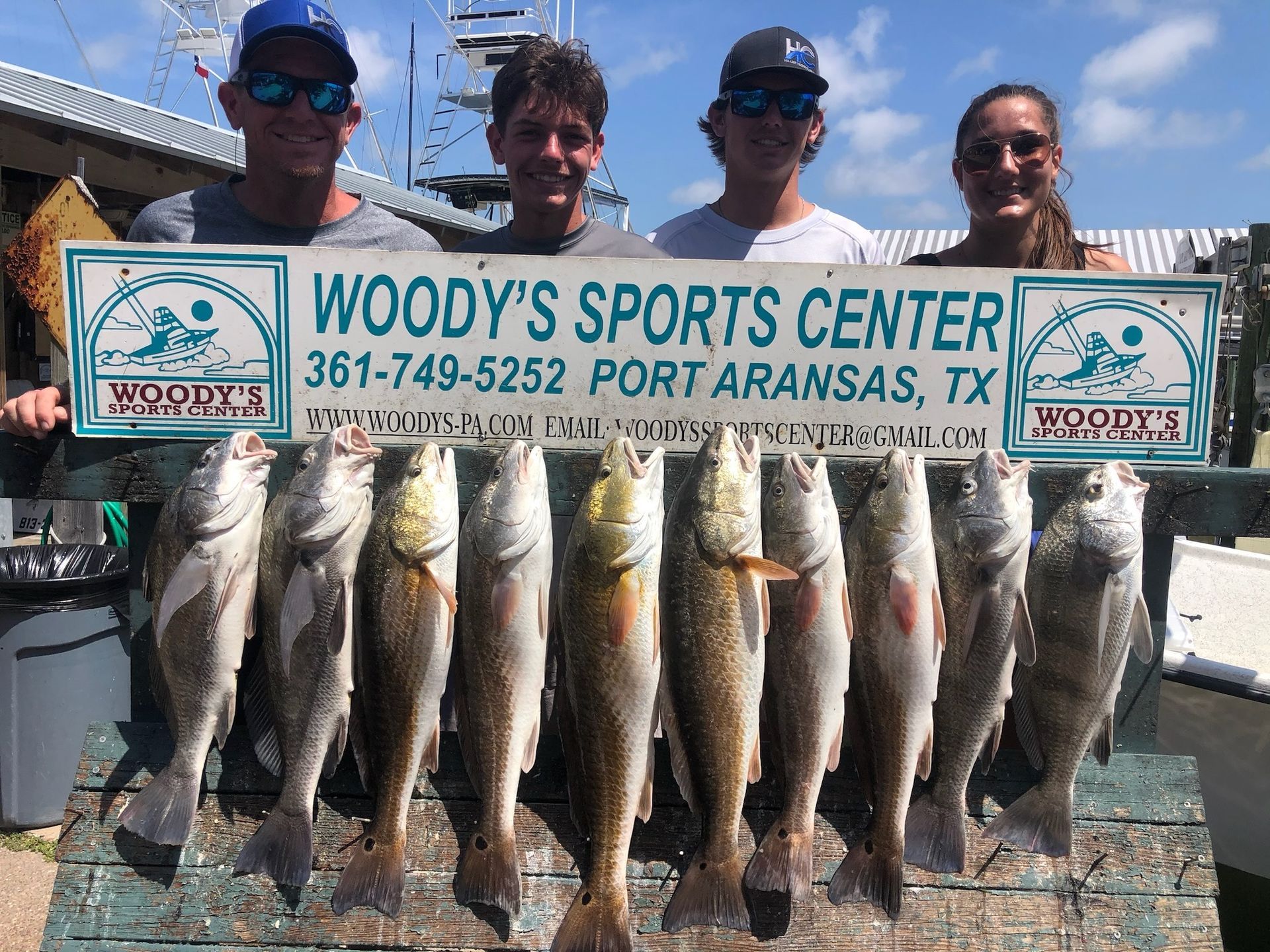 A group of people are holding a sign that says woody 's sports center.