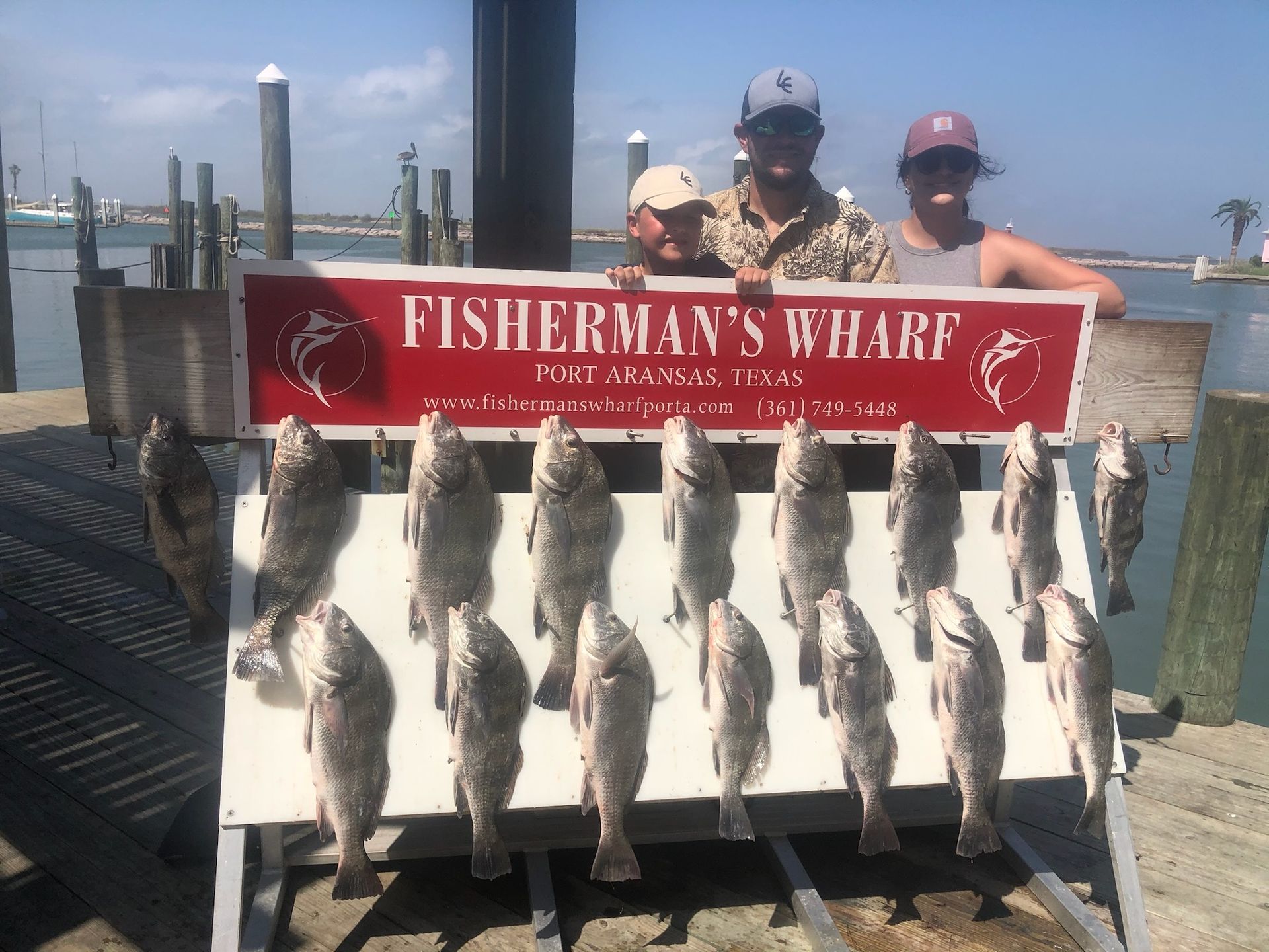 A group of people standing next to a sign that says fisherman 's wharf