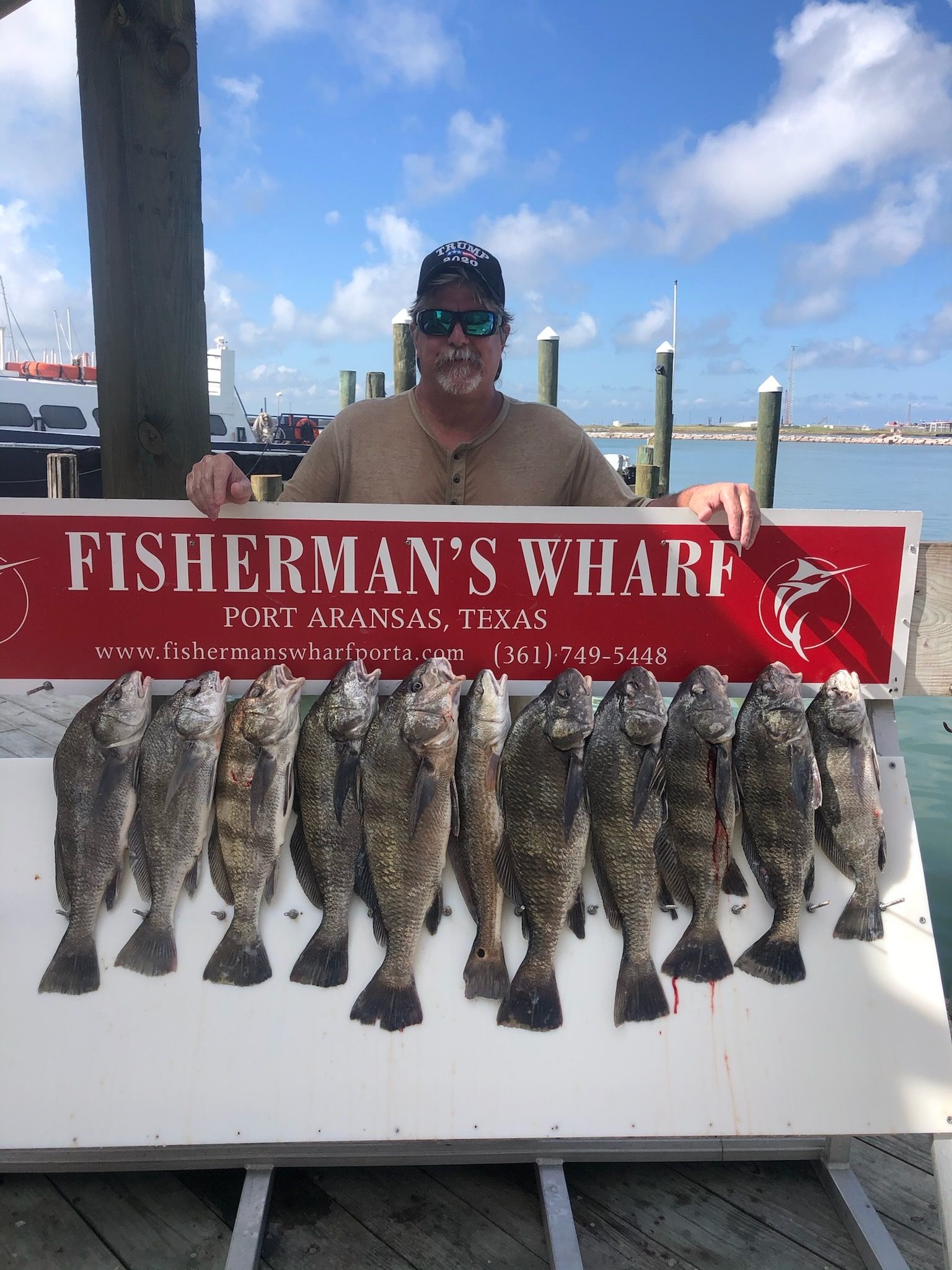 A man is holding a sign that says fisherman 's wharf