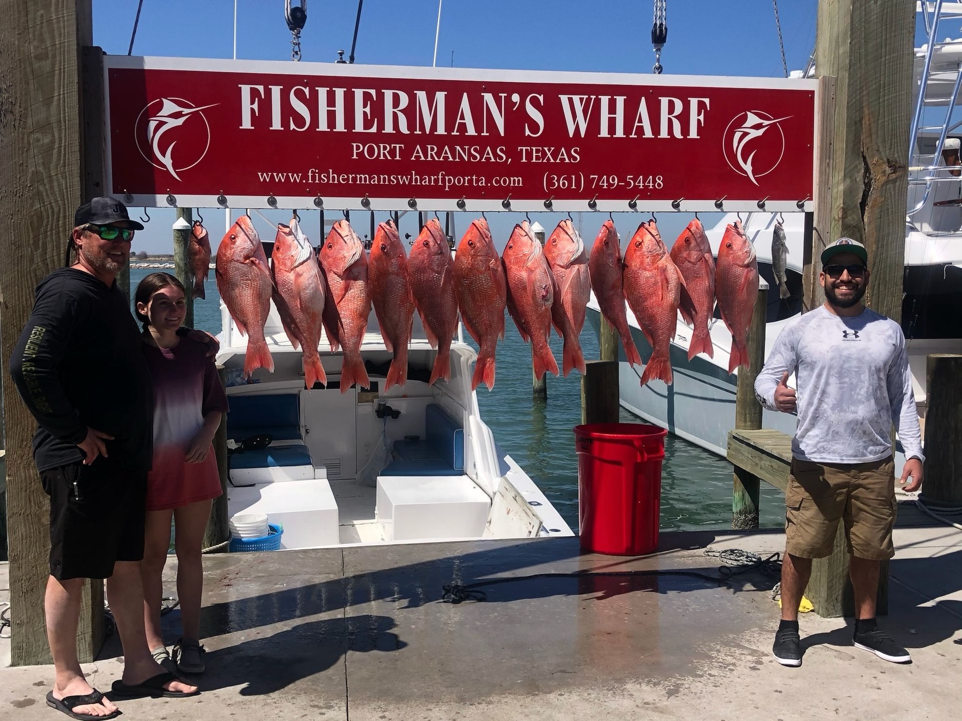 A group of people standing in front of a sign that says fisherman 's wharf