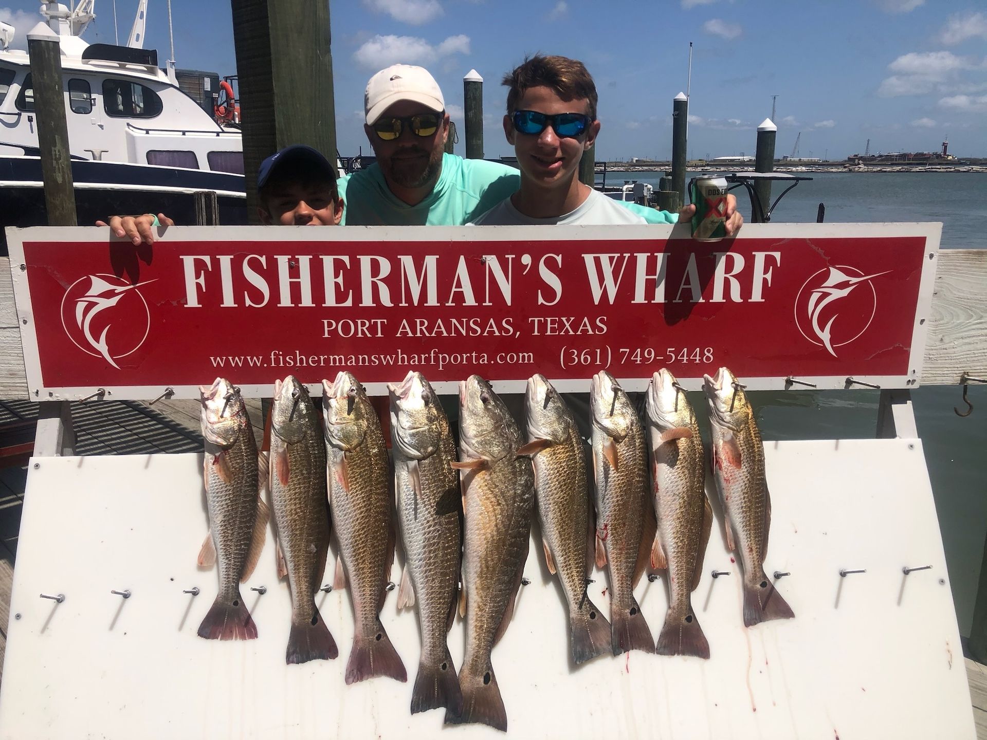 Two men holding a sign that says fisherman 's wharf