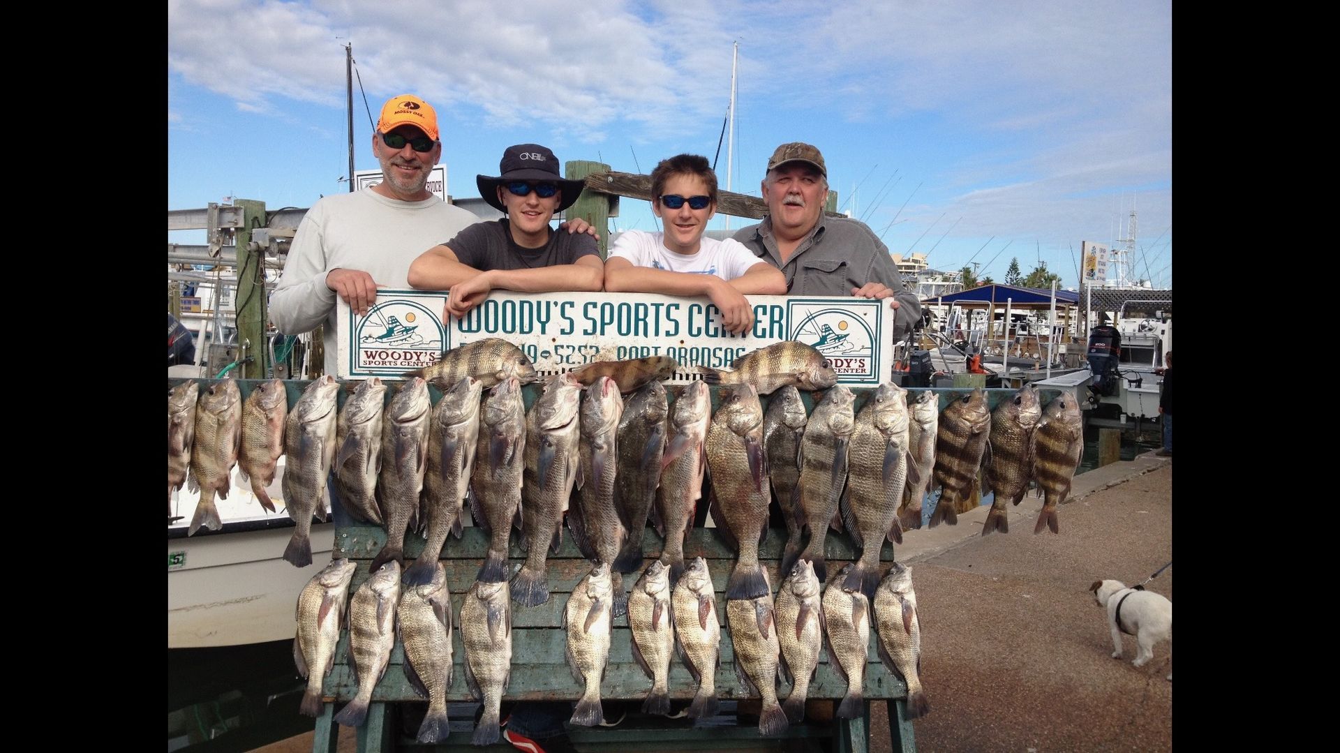 A group of men standing next to a table full of fish.
