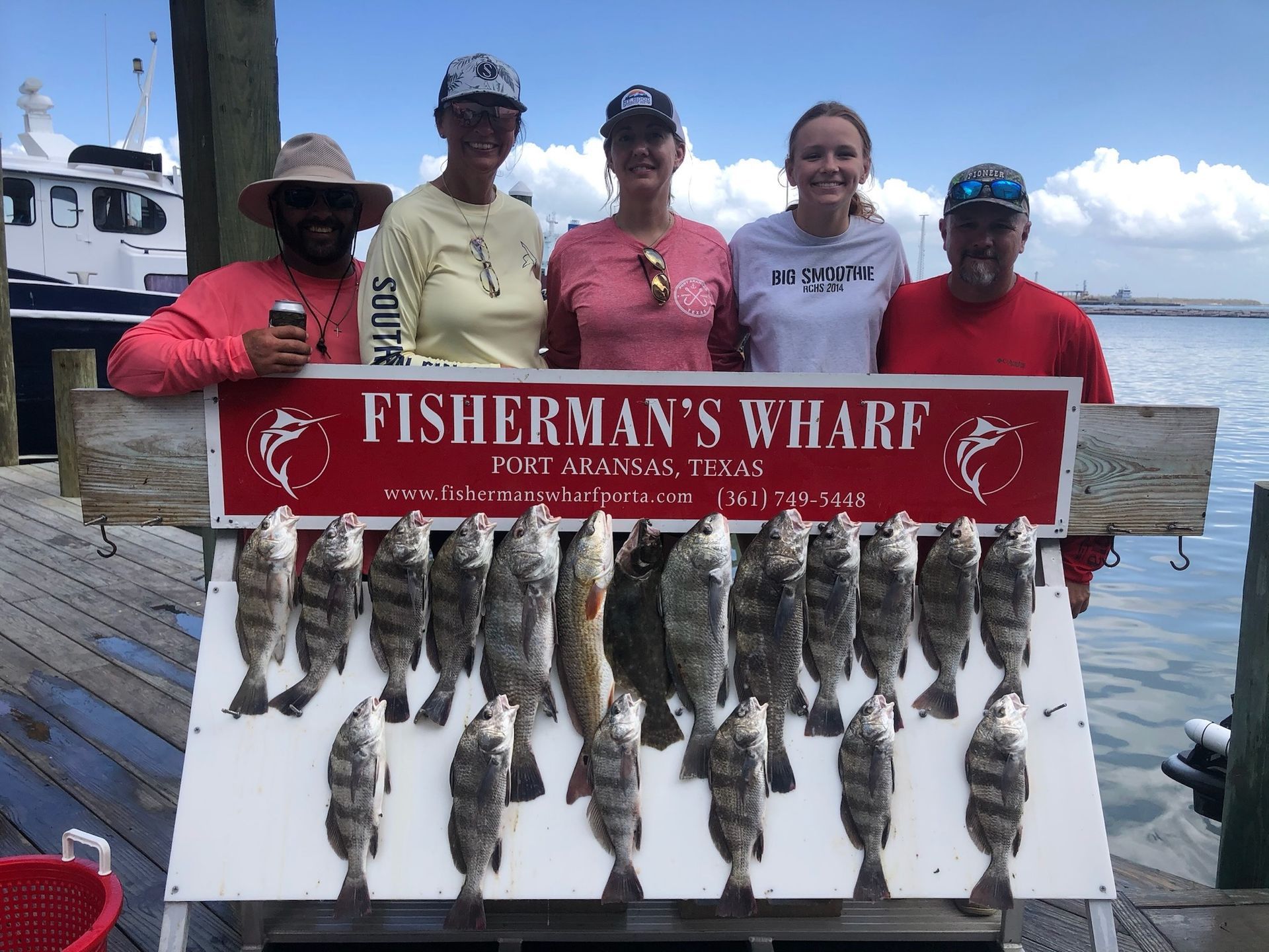 A group of people standing next to a sign that says fisherman 's wharf