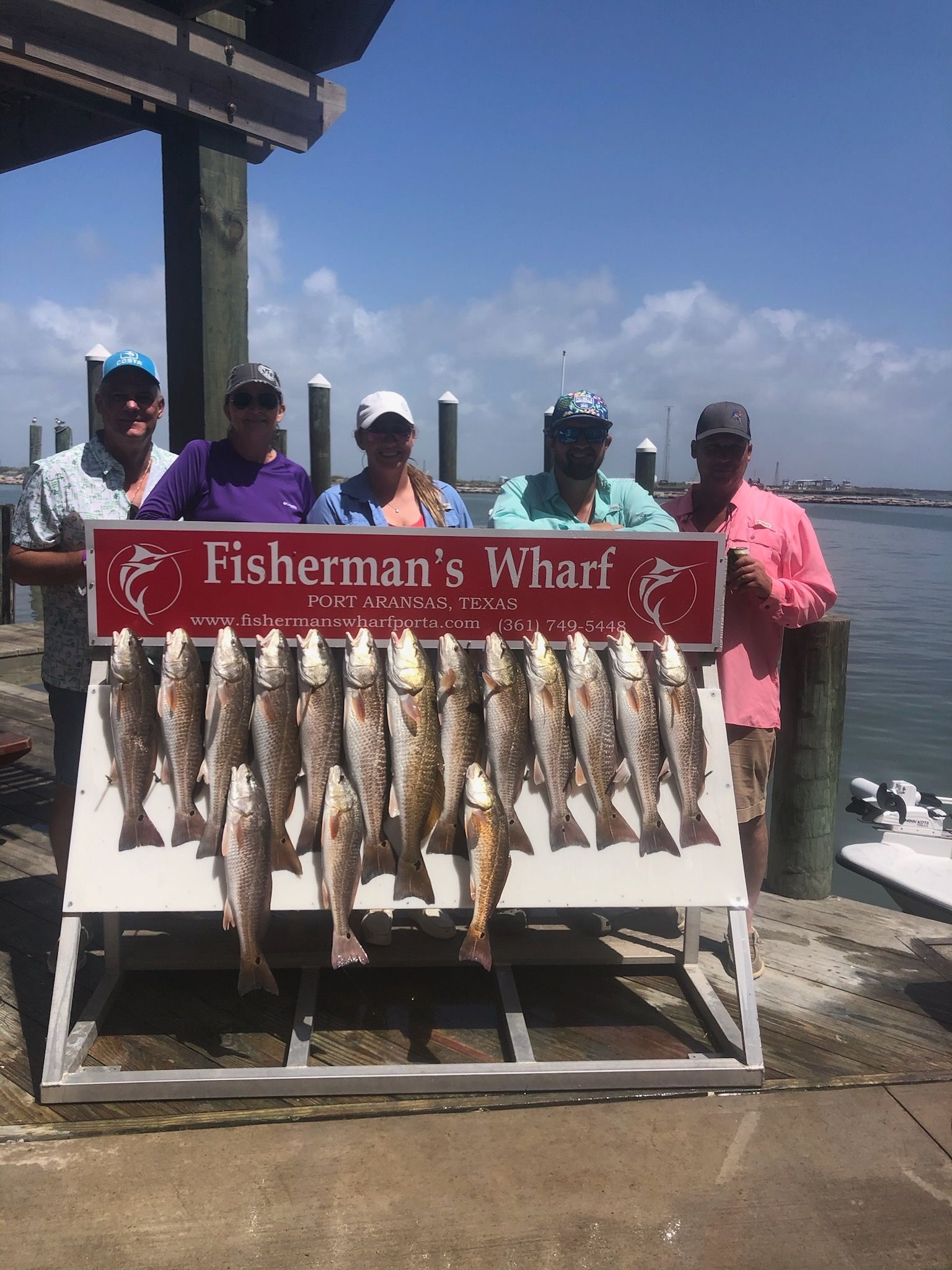 A group of people standing next to a display of fish.