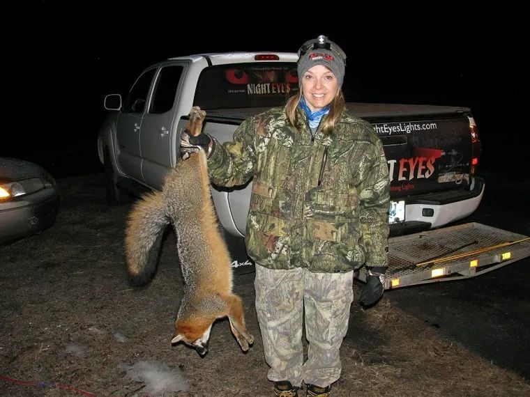 Hunter standing beside a hanging fox tailgate in front of a pickup truck at night