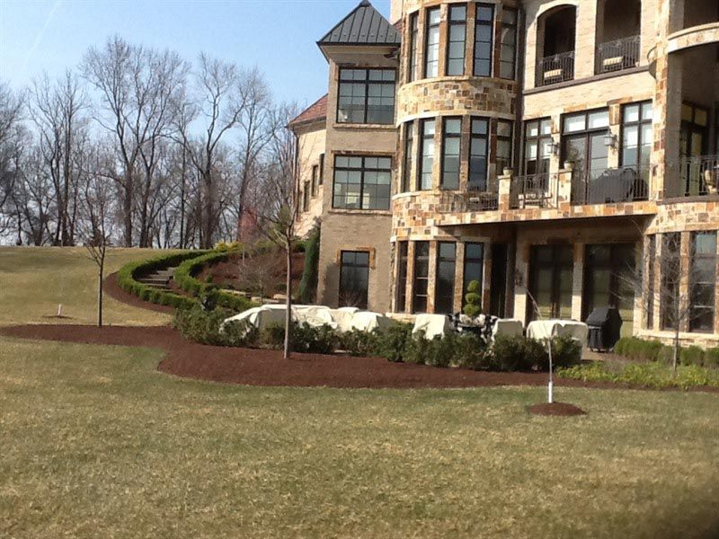 A large house with a lot of windows sits on top of a hill