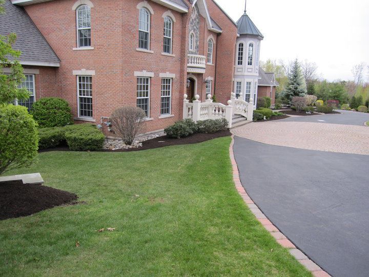 A large brick house with a driveway leading to it