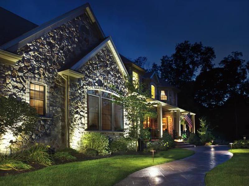 A large stone house is lit up at night