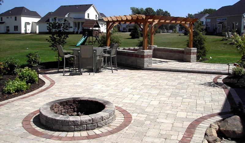 A patio with a fire pit and a pergola