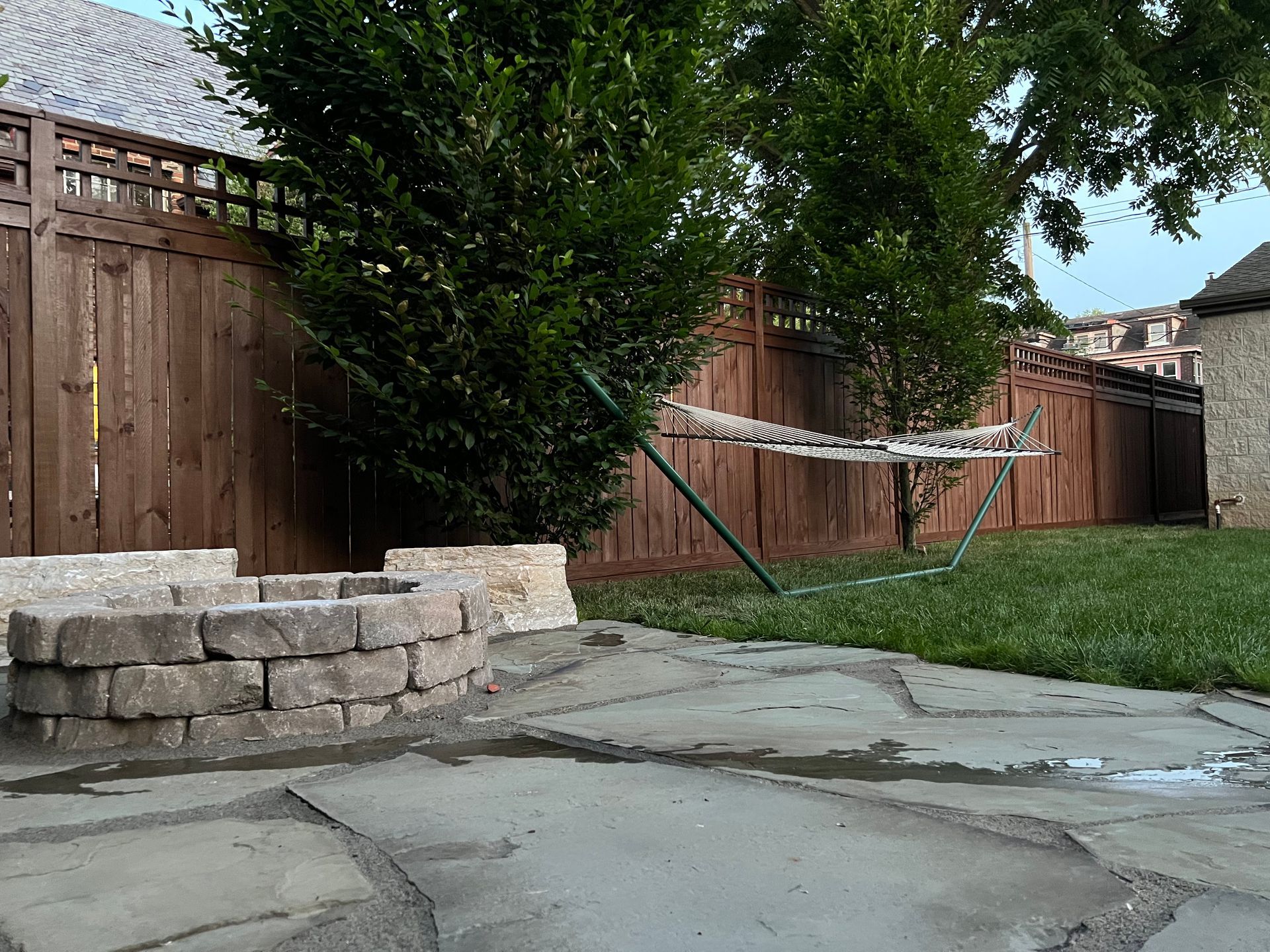A backyard with a fire pit and a wooden fence