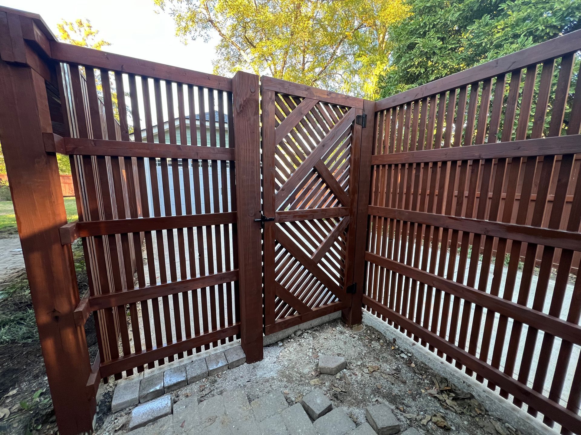 A wooden fence with a gate in the middle of it.