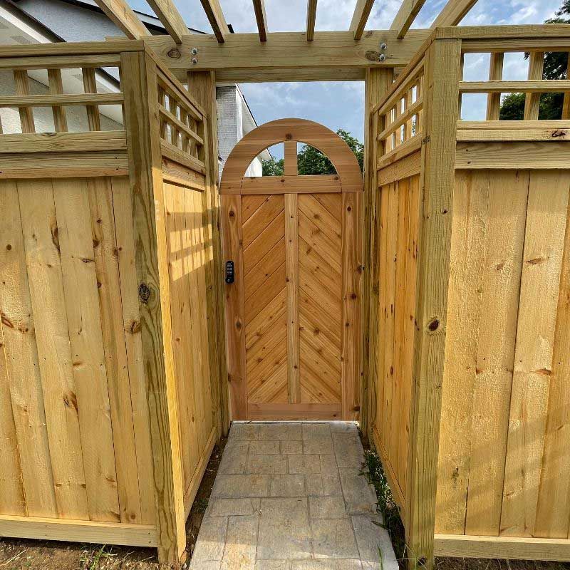 A wooden fence with a wooden gate in the middle